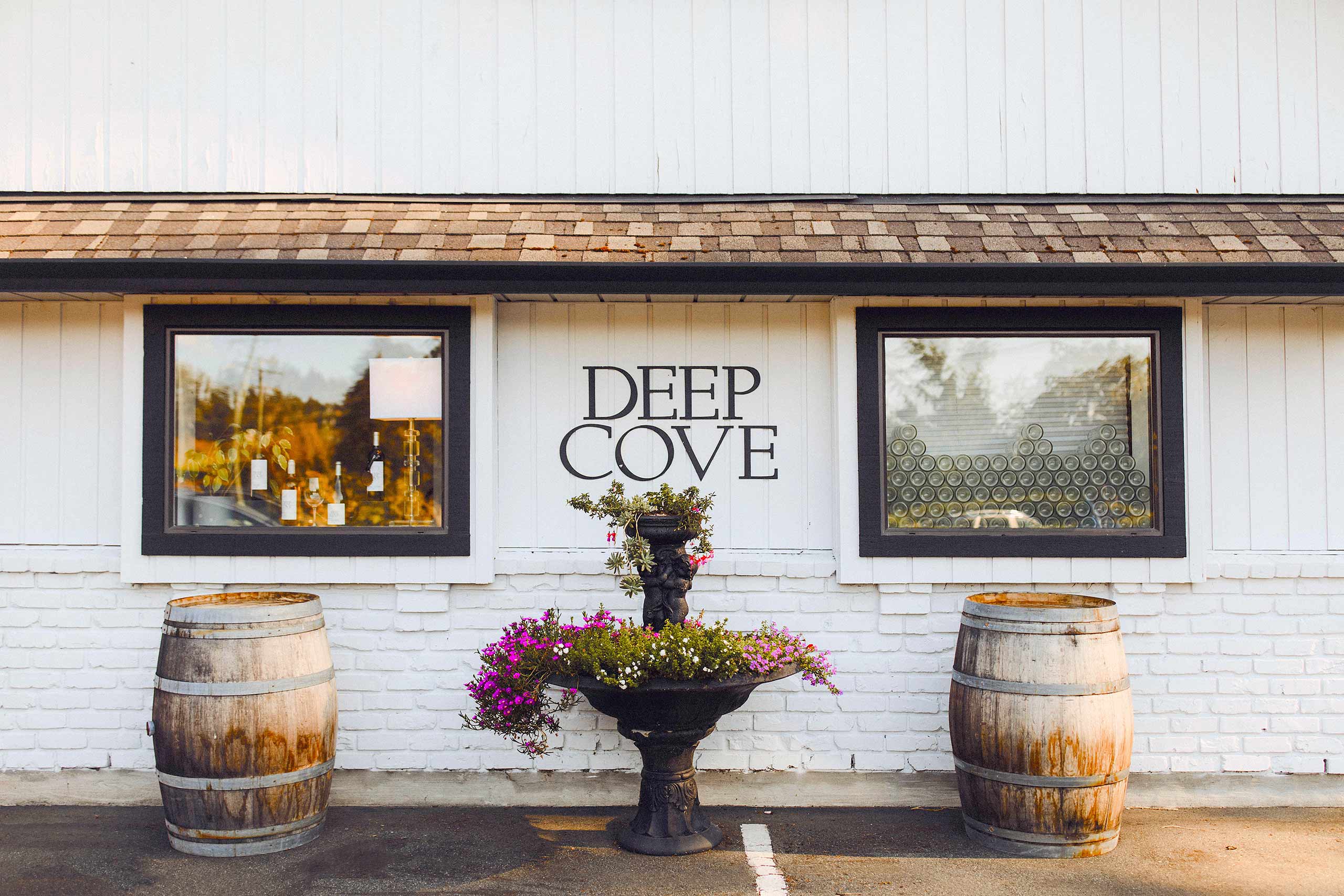 Deep Cove main building with barrels and flower bouquet with warm beautiful sunset lighting